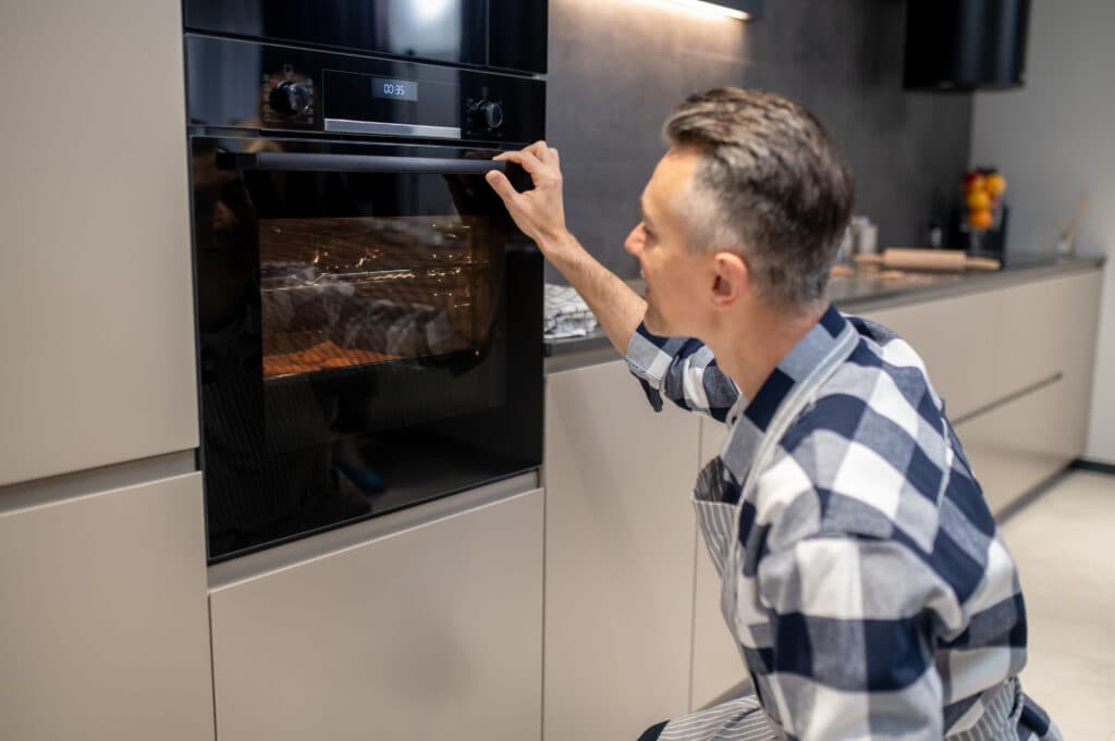 A person looking at a broken appliance